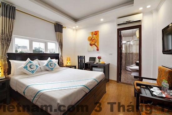 Phòng ngủ Hanoi Focus Boutique Hotel có giường đôi và nội thất gỗ sáng