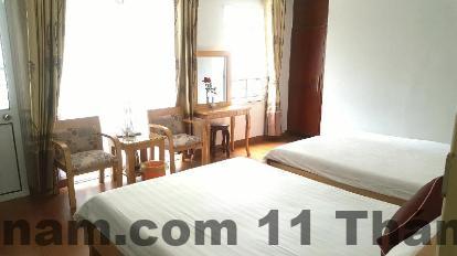 Phòng tiêu chuẩn khách sạn Hoàng Anh với giường đôi và nội thất gỗ truyền thống