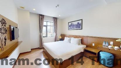 Phòng nghỉ tại Central Hotel & Spa với nội thất gỗ sáng màu và thiết kế đơn giản