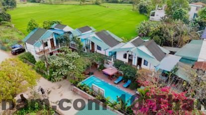 Không gian phòng ngủ nhà sàn tại Nùng An Homestay với nội thất gỗ đơn giản