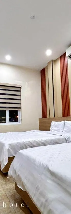 Không gian phòng nghỉ tại Khách sạn Hùng Phương với nội thất cơ bản, giường và TV