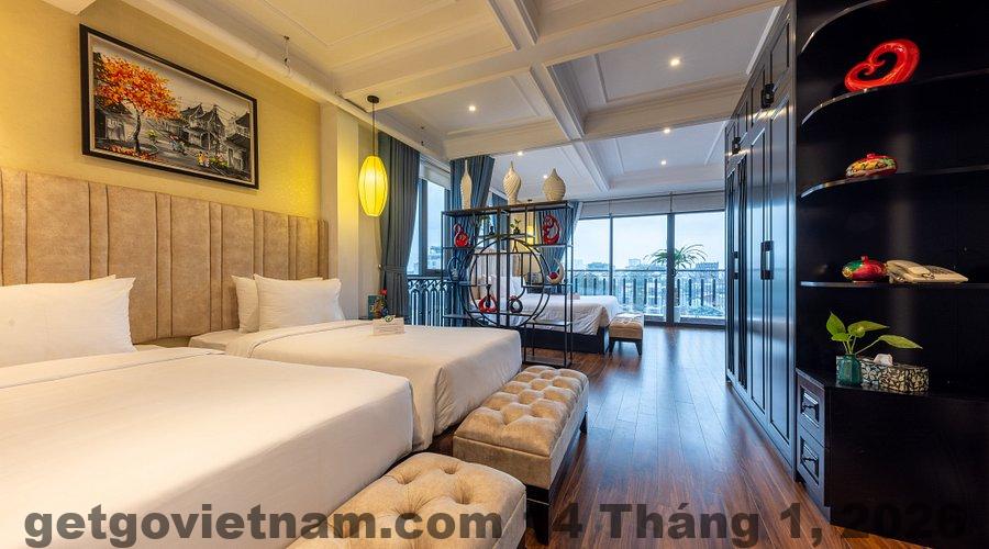 Phòng ngủ giường lớn tại Thu Đo Vang Hotel với nội thất tông vàng nâu và diện tích rộng