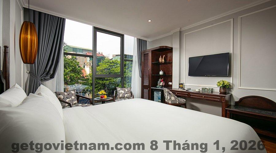 Phòng ngủ tại Salute Premium Hotel & Spa với giường lớn, nội thất hiện đại, tông màu ấm