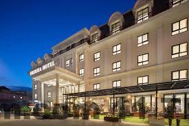 Nhân viên phục vụ khách tại sảnh khách sạn với nụ cười tươi, thể hiện sự chuyên nghiệp.