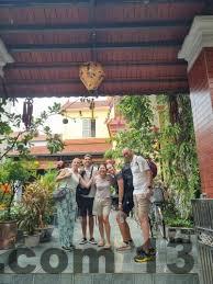 Mặt trước khách sạn với không gian thoáng đãng và cây xanh xung quanh.