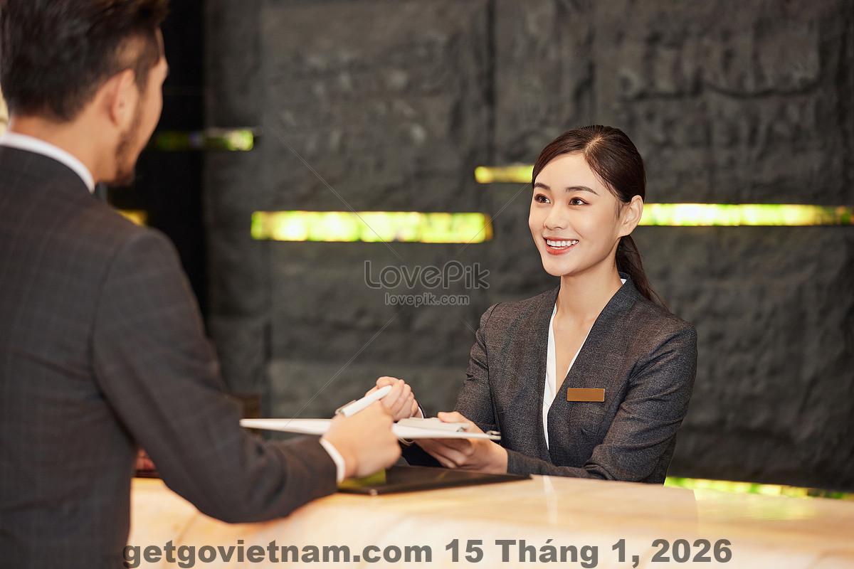 Quầy lễ tân khách sạn với nhân viên hỗ trợ check-in cho khách