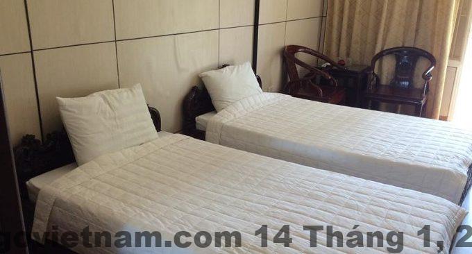 Phòng nghỉ tiêu chuẩn tại Huong Tra Hotel với giường lớn, nội thất gỗ và thiết kế truyền thống