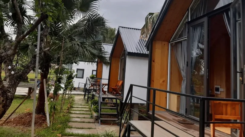 Không gian phòng ngủ Stream House thiết kế gỗ mộc, cửa kính lớn nhìn ra thiên nhiên